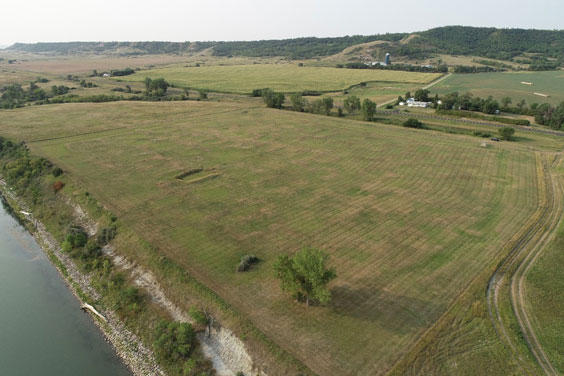 An aeiral view of a patch of land where the indentation of a ditch surrounding it can be seen as well as a rectangular indent in the middle