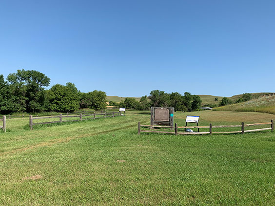 green field with state historical site markers