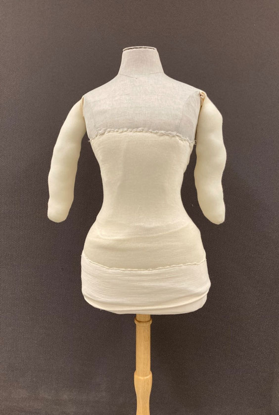 The bust and hips of a mannequin with cloth covering and stuffed arms attached