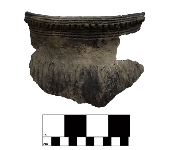 A dark brown piece of broken pottery with thin horizontal lines surrounding thicker vertical lines at the top 