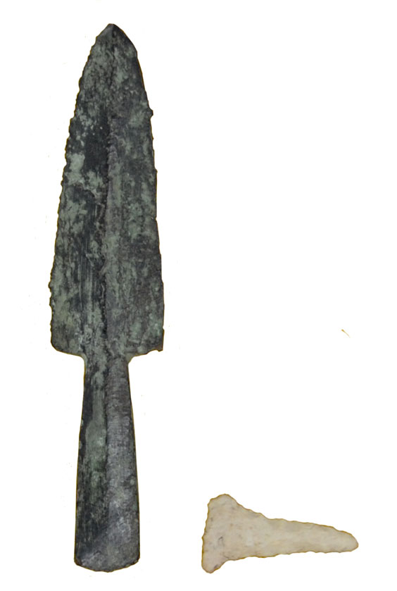 A dark gray drill made out of stone and a tanish colored point that looks similar to a long tooth