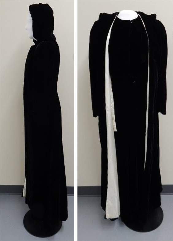 A full length, hooded, long sleeved black velvet coat. There is a button at the neckline and ties around the waist.