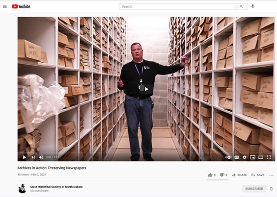 Screenshot of YouTube with a man standing in between rows of shelves full of boxes