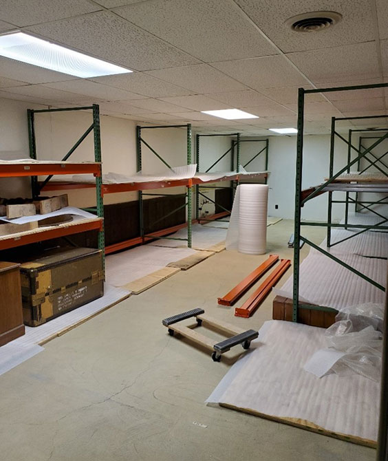 A storage room is shown with empty shelving units on both sides
