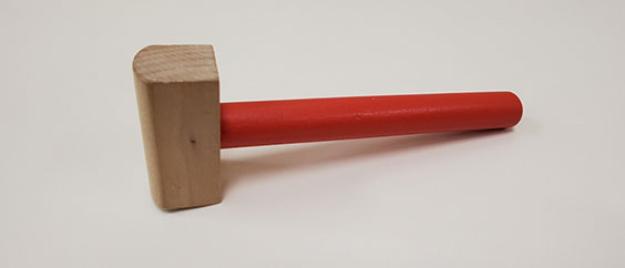 A wooden gavel with a red handle
