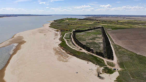 an aerial view showing water on the left, then sand, and then land.