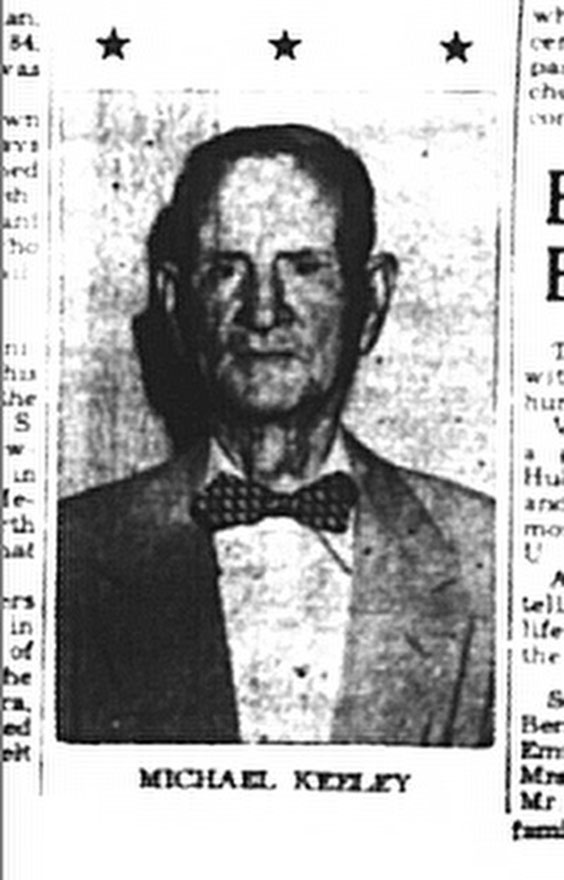 black and white image of an older man wearing a white button up shirt, suit jacket, and bowtie