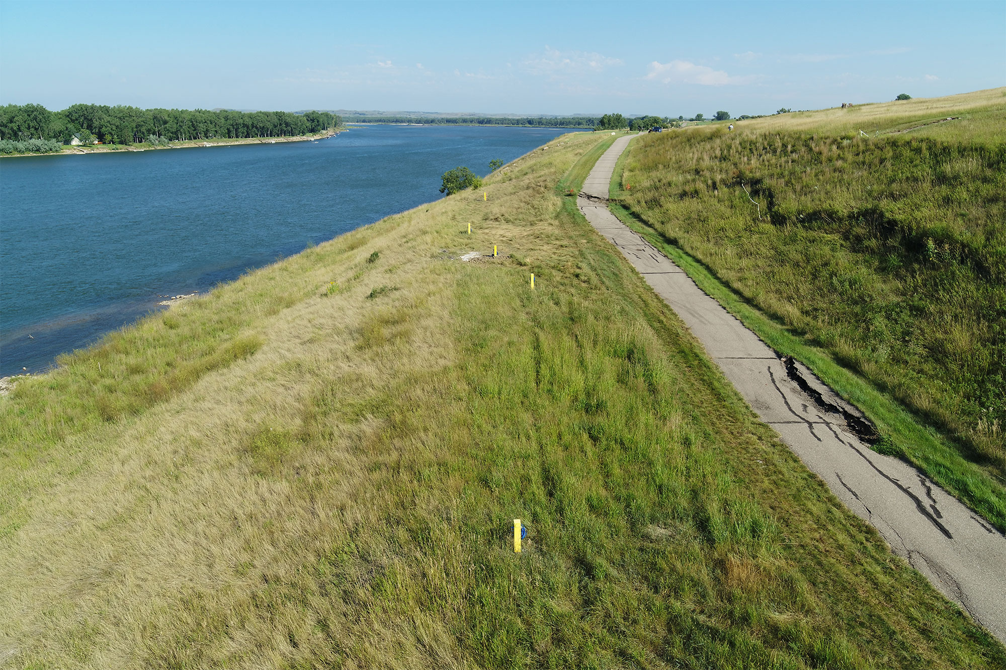 Large cracks in the pedestrian path and the location of geotechnical instruments monitoring ongoing slumping indicated by yellow posts are seen in this drone image