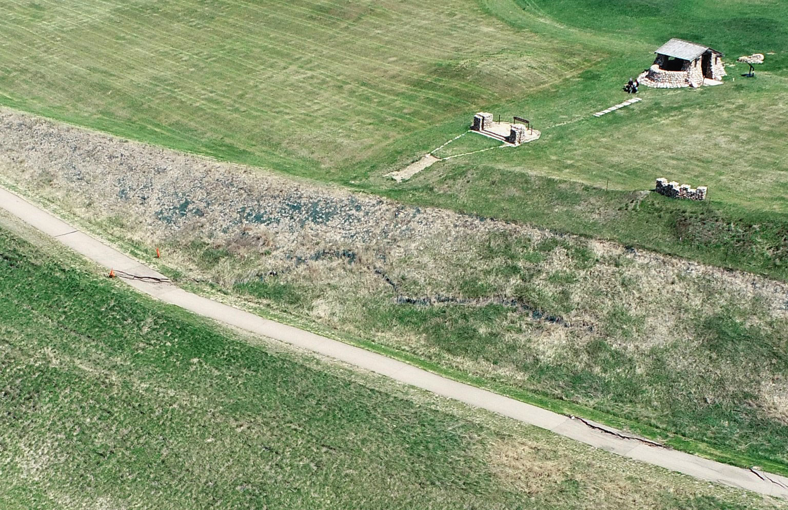 Large cracks are seen on the pedestrian path and a slope close to the WPA shelter at the Double Ditch in this drone image