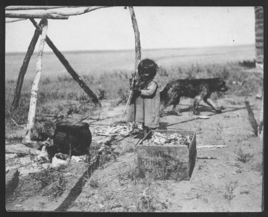 Child with dog and cooking pot