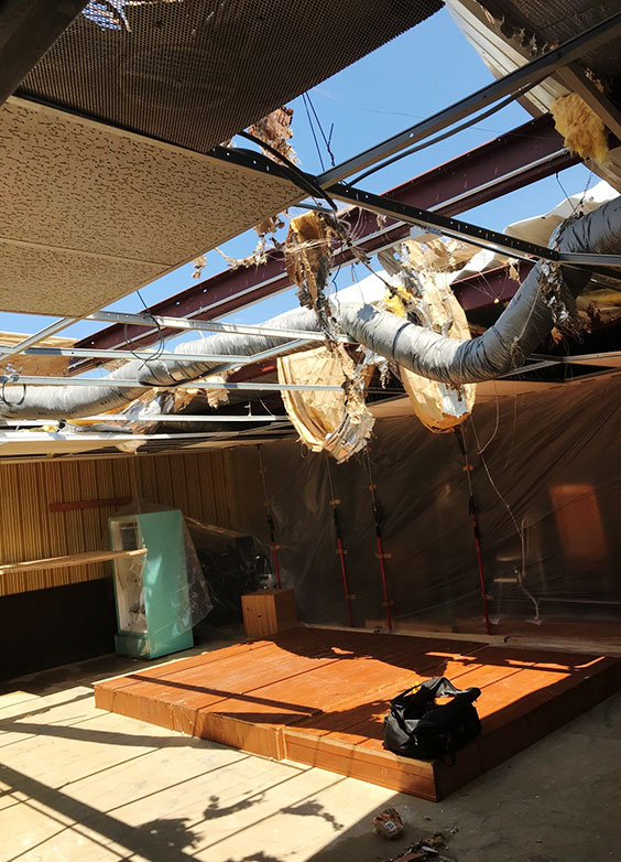 damaged ceiling showing debris and sky viewable through large holes