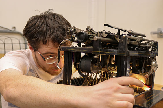man works on vintage typewriter