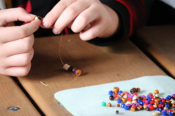 Beads being added to string