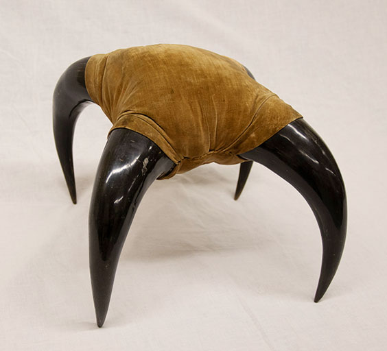 brown cloth footstool with horn legs