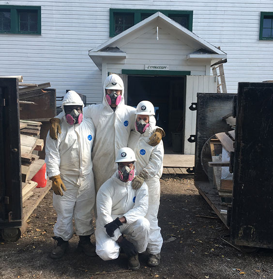 AmeriCorps team members in hazmat suits outside gymnasium