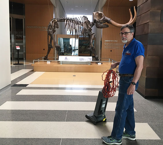 Bob standing with a vacuum by the Mastodon