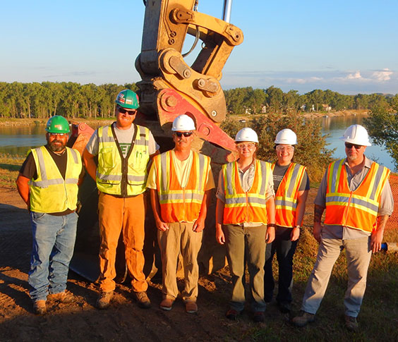 Employees standing in front of construction equipment