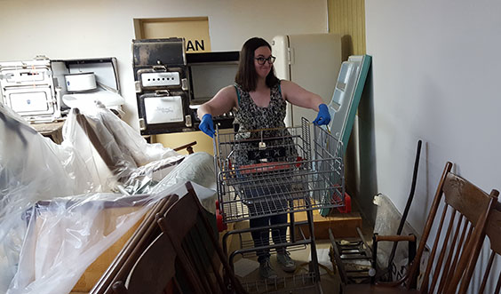 person wearing gloves measures the width of a shopping cart