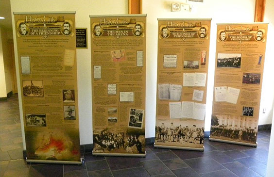Four tan colored exhibit banners with text and images. Some of the images are documents. Others are of people and horses.