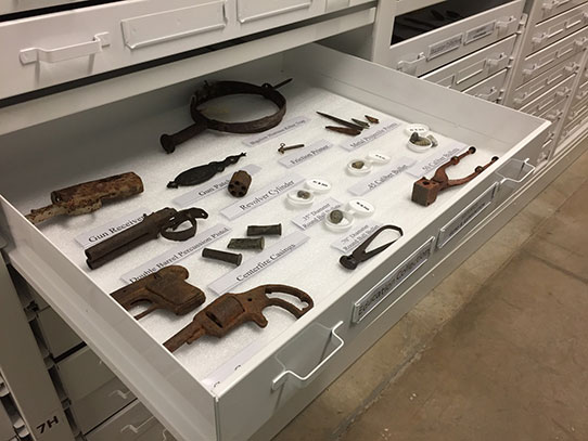 Drawer of guns, gun parts, bullets, and ammunition molds