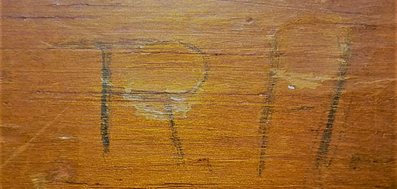 Initials R.H. written on wood 
