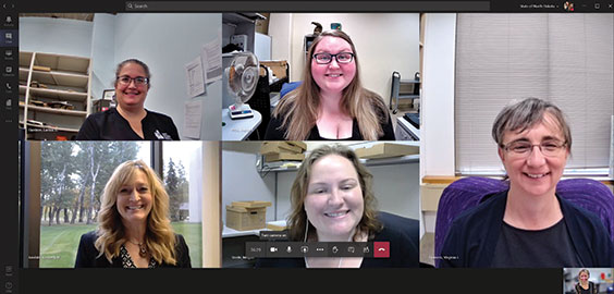 five women are shown in their own squares on a computer screen. All are looking at the camera smiling.