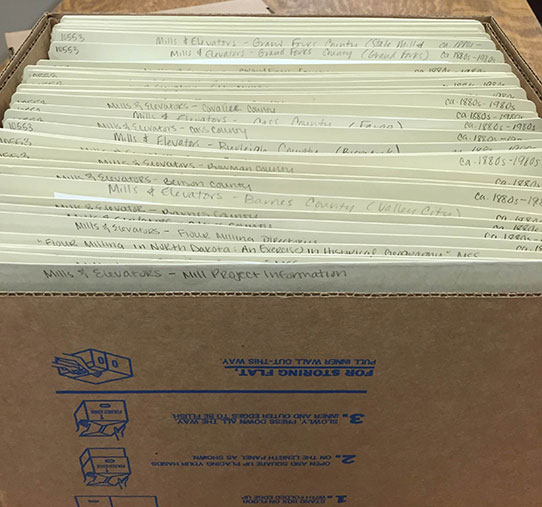 Box of folders with processed records from the Mill & Elevator Sub Subseries