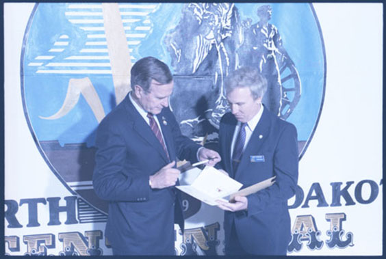 Picture of President George H.W. Bush and another man holding papers