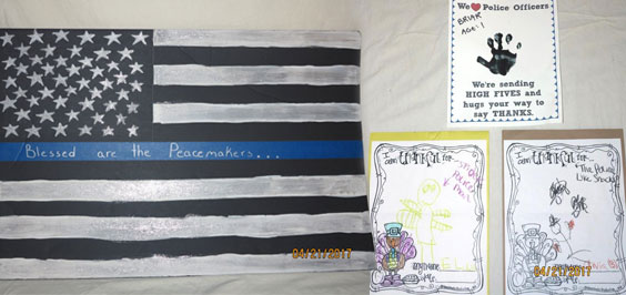 Painted American Flag with blue stripe reading Blessed are the Peacemakers... and three pictures supporting law enforcement