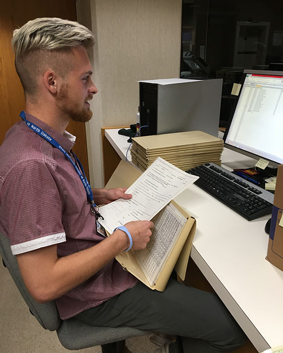 College-aged man sitting at a computer working